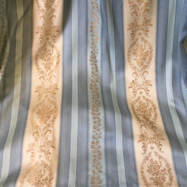 Pair of blue striped lined curtains with gold floral accents.