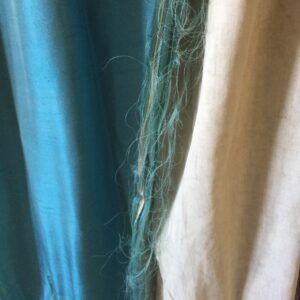 Pair of peacock blue silk curtains. Lined. Major distress along the edges of one side of each curtain