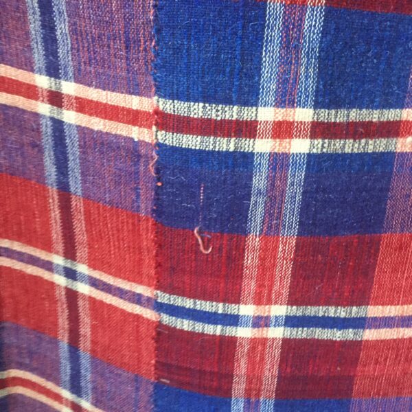 Hand woven red white and blue plaid blanket. This piece was woven in three strips that were then sewn together