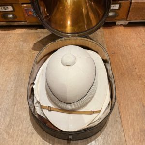 Pith helmet with original metal carrying case. Made by Gieves Limited of London and Edinburgh. Size 7. Hat belonged to Capt. J. S. M. Ritchie , R. N.